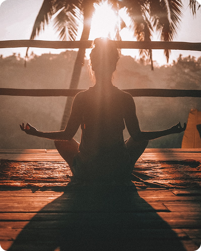 Woman meditating at sunset
